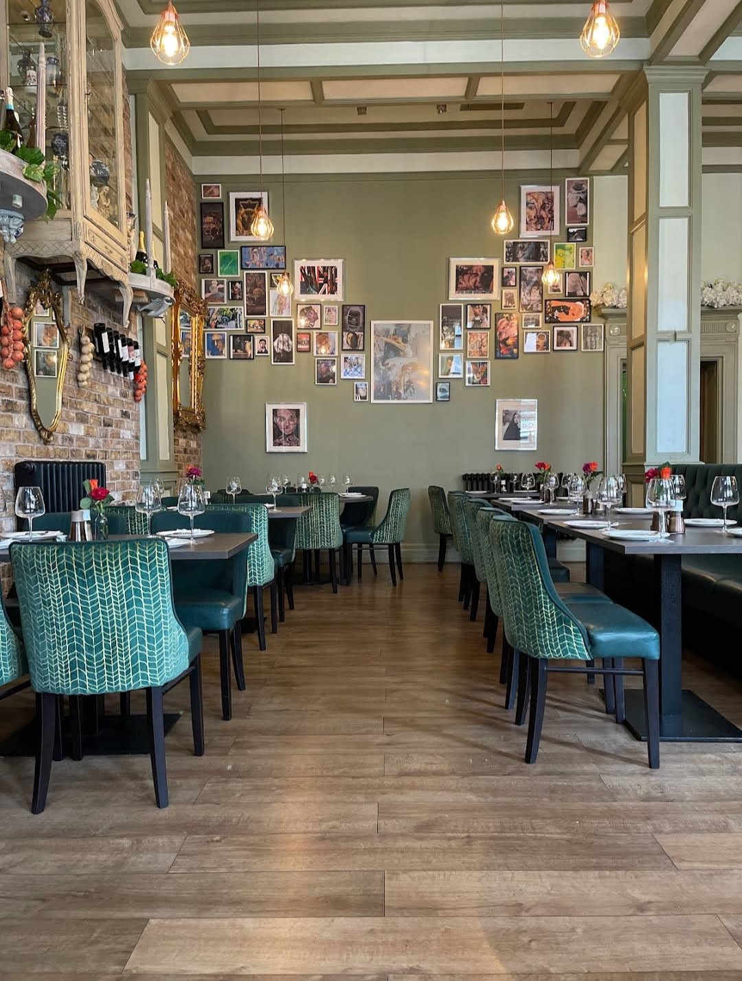 Spacious dining room with teal herringbone chairs and gallery wall