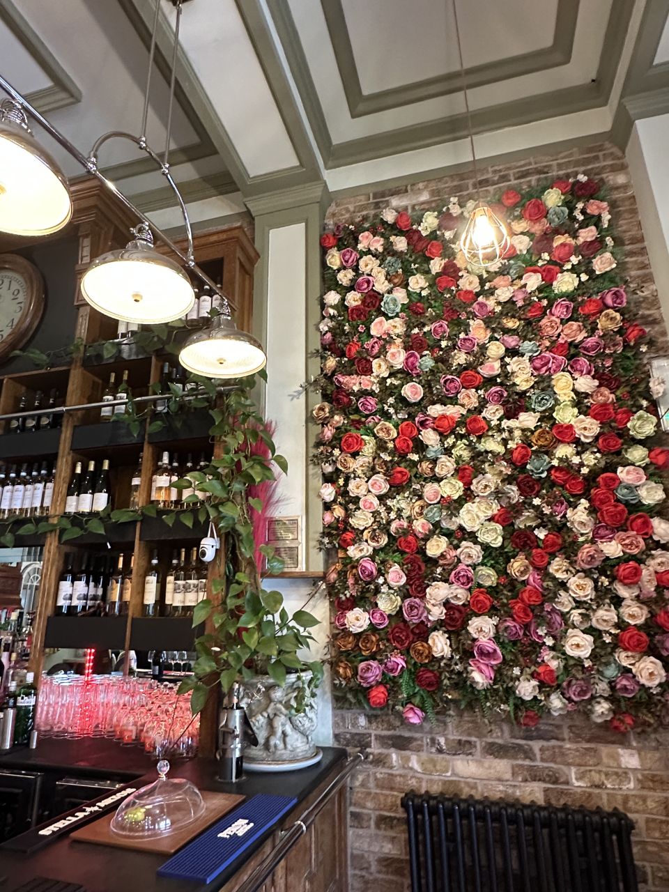 Bar with rose flower wall, vintage clock and pendant lights