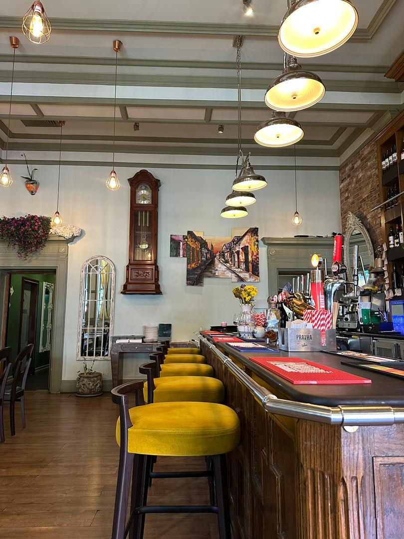 Mustard bar stools beneath statement pendant lights