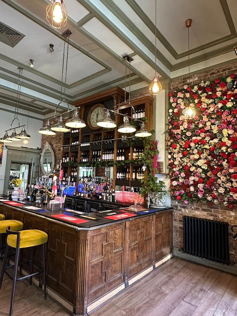 Classic bar with floral wall and warm pendant lighting